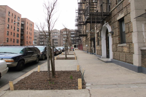 Eine spärliche Stadtlandschaft mit wenigen Autos und Gebäuden in der rechten Ecke und einigen anderen Gebäuden in der linken Ecke.