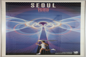 Eine Person, die mit den Olympischen Ringen im Hintergrund läuft, und die Wörter "Olympische Spiele" quer über die Spitze geschrieben, auf einem Plakat für die Olympischen Spiele 1988 in Seoul, Südkorea.