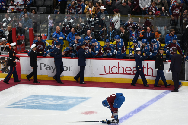 Eishockeyspieler auf dem Eis umgeben von Teamkollegen und Gegenspielern während eines Spiels von Colorado Avalanche gegen San Jose Sharks am 3/24/15.