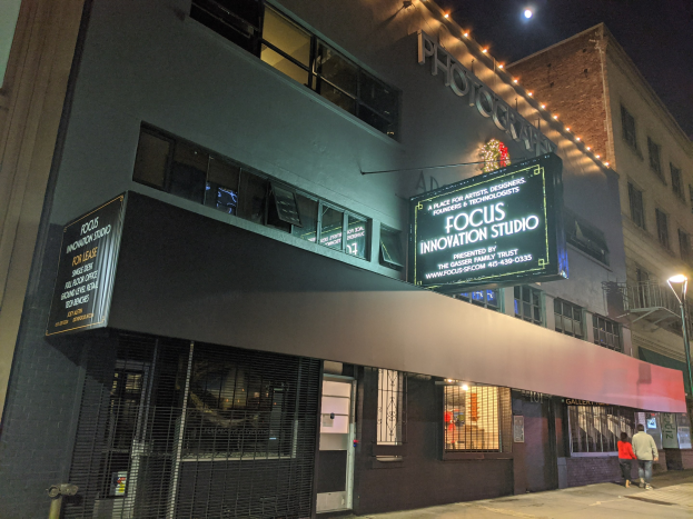 Außenansicht des Focus Innovation Studios in New York City bei Nacht, mit Menschen auf dem Bürgersteig und beleuchteten Gebäuden im Hintergrund.