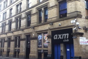 Ein Schaufenster mit Plakaten und ein Gebäude im Vordergrund.