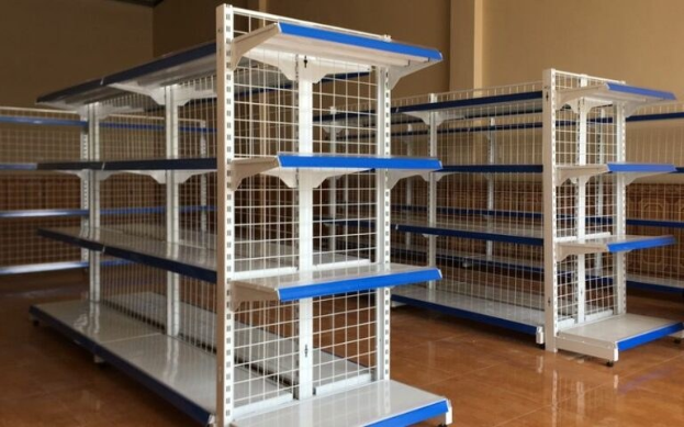 Ein großes Metallregal in einem gut gepflegten Lagerhaus mit einer Wand im Hintergrund und einer Decke mit Leuchten oben.