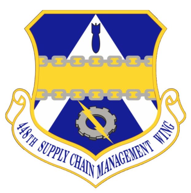 Logo des 48. Versorgungsmanagementgeschwaders mit einem blauen Schild mit einem weißen Stern, einem weißen Banner mit blauem Text 'Versorgungsmanagement' und schwarzem Text '48. Versorgungsmanagementgeschwader' in fetter Schrift.