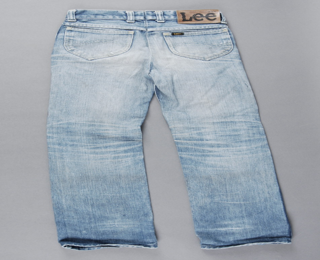 Ein Paar Levi's 501 Original Fit Jeans in hellblauem Denim mit einem Vintage-Fade-Effekt, präsentiert auf einem grauen Hintergrund, mit einem Fünf-Taschen-Design, Reißverschluss und Knopfverschluss sowie dem ikonischen Levi's-Logo auf der Gesäßtasche.
