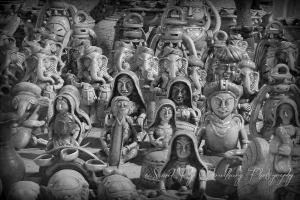 Mehrere Ganesha-Statuen sowie Figuren von Frauen und Männern sind in diesem Bild zu sehen.