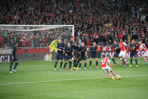 Fußballspieler auf einem Feld mit einer großen Menge im Hintergrund.