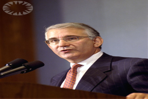 Ein Mann mit Brille spricht in mehrere Mikrofone.