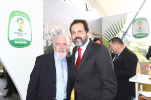 Eine Gruppe von Menschen, die mit einigen, die lächeln, vor einem FIFA-Weltmeisterschaftsplakat steht.