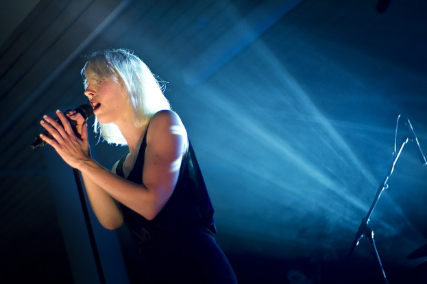 Eine Frau singt in ein Mikrofon.