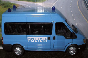 Ein Spielzeugauto vor einem Plakat.