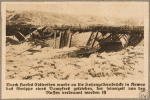 Ein altes Schwarz-Weiß-Foto einer abgerissenen Brücke mit ein paar Menschen darauf und Text am unteren Rand.